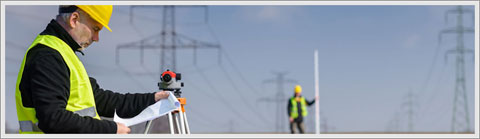 Two men surveying next to power lines